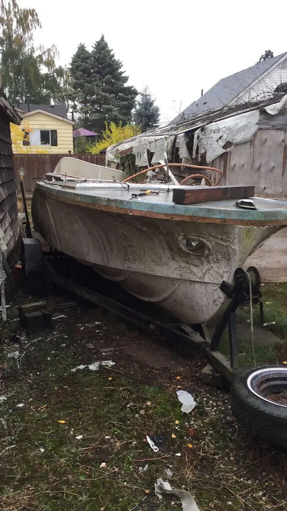 Old boat on a trailer removed from a backyard