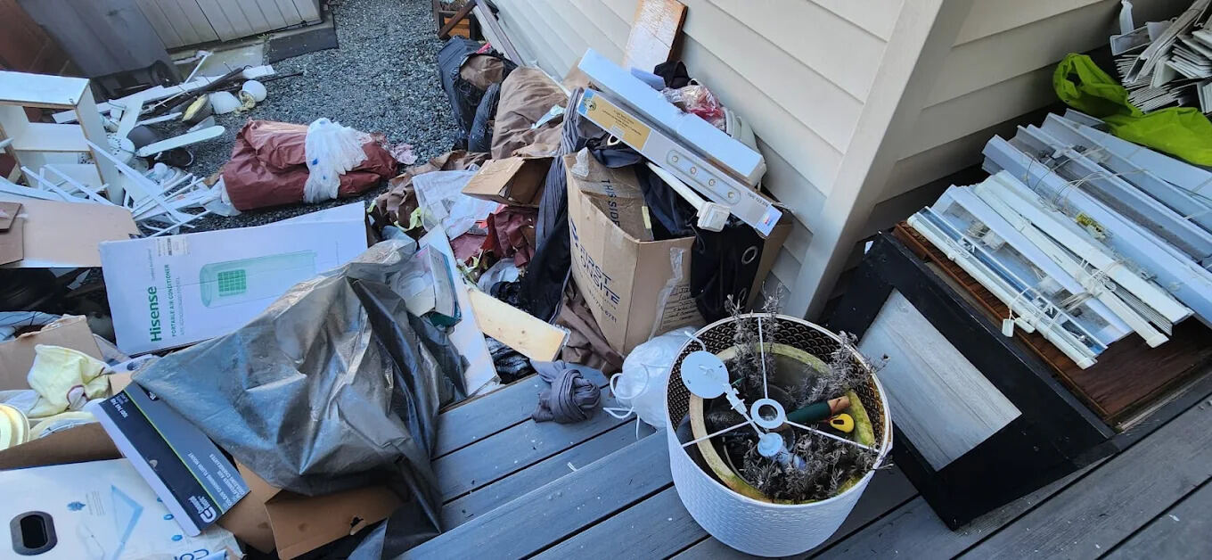 Household items and boxes piled on a back deck for removal