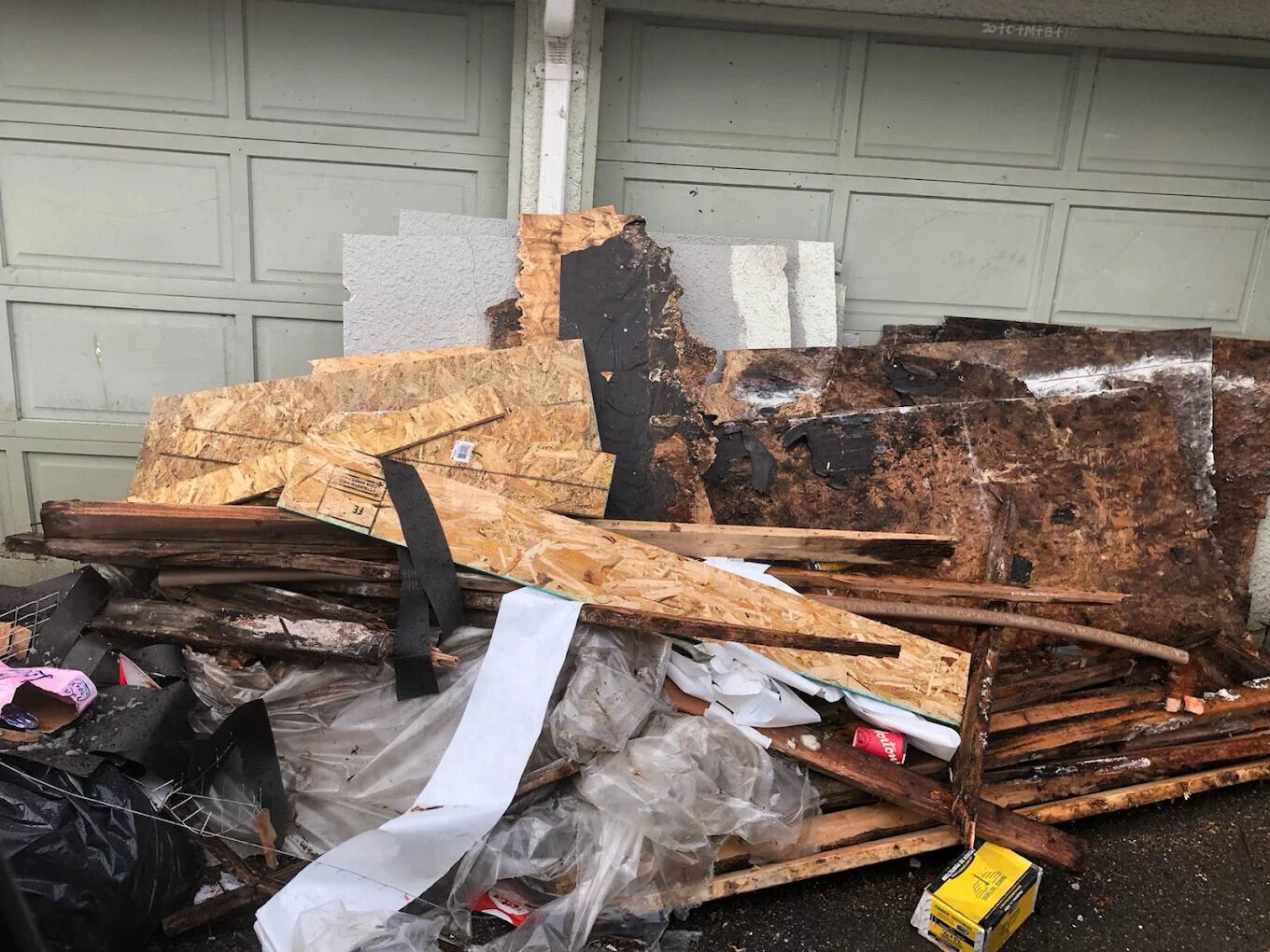 Renovation debris including insulation and boarding stacked for disposal